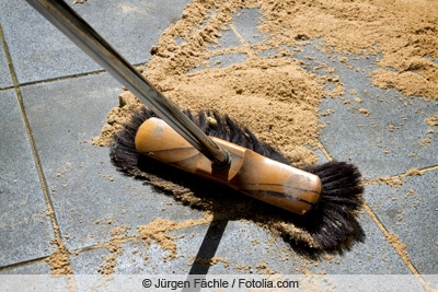 Steine reinigen mit Besen und Sand